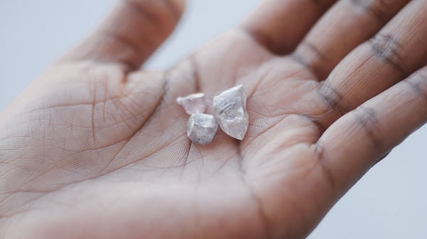 1280-Employee-holding-three-rough-diamonds-DBSSSA-Building-Kimberley-South-Africa-credit-Ben-Perry-slash-Armoury-Films-slash-De-Beers